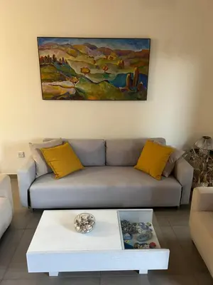 a living room with a couch and a painting on the wall at Beautiful maisonette in Protaras in Protaras