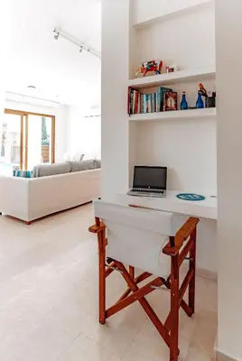 a desk with a laptop on it in a living room at WealthyStays Sunset Villa, 3min walk to Sea in Paralimni
