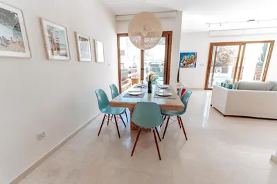 a dining room with a table and blue chairs at WealthyStays Sunset Villa, 3min walk to Sea in Paralimni