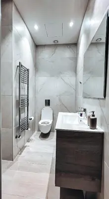 a white bathroom with a toilet and a sink at SkyHigh Central 360 Gym & Pool in Nicosia