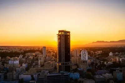 a tall building in a city at sunset at SkyHigh Central 360 Gym & Pool in Nicosia