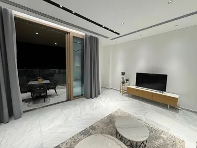 a living room with a television and a table with chairs at SkyHigh Central 360 Gym & Pool in Nicosia