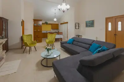 a living room with a blue couch and yellow chairs at Eidyllio ''The Mansion'' in Omodos