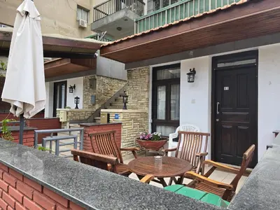 a patio with chairs and a table and an umbrella at Maryland Lodge kakopetria in Kakopetria