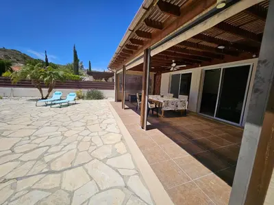 a patio with a table and chairs on a house at Villa Penny in Pissouri
