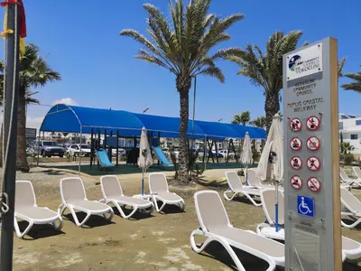 a group of chairs and umbrellas on a beach at Miranda Beach House in Voroklini