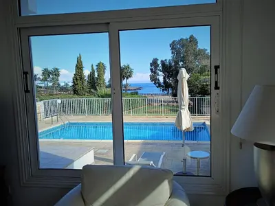 a living room with a view of a pool through a sliding glass door at Horizon Villa Protaras in Protaras