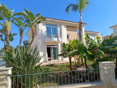 a house with palm trees in front of it at Horizon Villa Protaras in Protaras