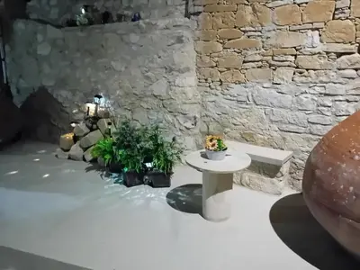 a room with a table and plants and a brick wall at TRADITIONAL HOUSE ARSOS in Arsos