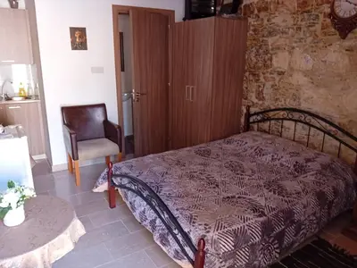 a bedroom with a bed and a chair and a table at TRADITIONAL HOUSE ARSOS in Arsos