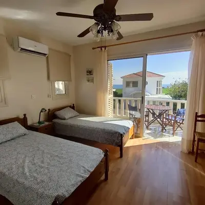 two beds in a room with a view of a balcony at Quiet holiday house near the beach in Meneou