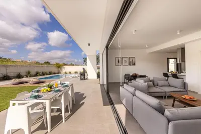 a living room with a table and chairs and a pool at Protaras By the Bay Villa 33 in Protaras
