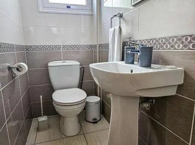 a bathroom with a white sink and a toilet at Nissi beach villa Holiday in Ayia Napa