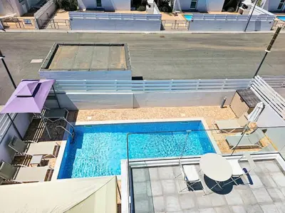 an overhead view of a swimming pool with chairs at Nissi beach villa Holiday in Ayia Napa