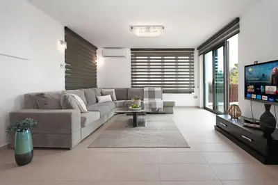 a living room with a couch and a tv at Villa Lara - 3bed Bangalow with Large Pool in Ayia Napa