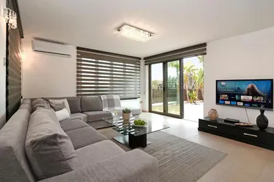a living room with a couch and a flat screen tv at Villa Lara - 3bed Bangalow with Large Pool in Ayia Napa