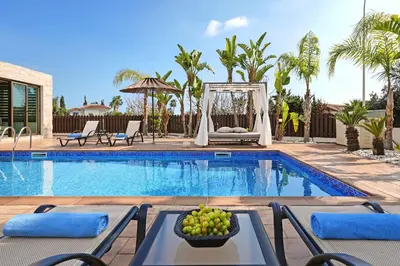 a pool with chairs and a fruit bowl on a table at Villa Lara - 3bed Bangalow with Large Pool in Ayia Napa