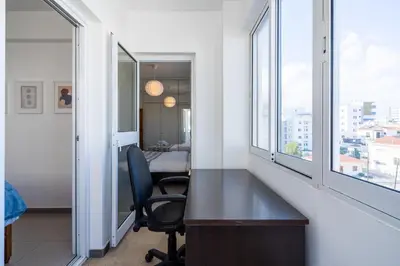 an office with a desk and two windows at Jayde 2-Bedroom Apartment in Larnaca in Larnaka