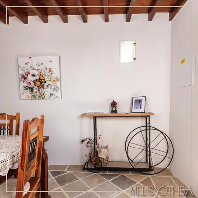 a room with a table and a bike in it at Melissothea Stone Suites in Mesana