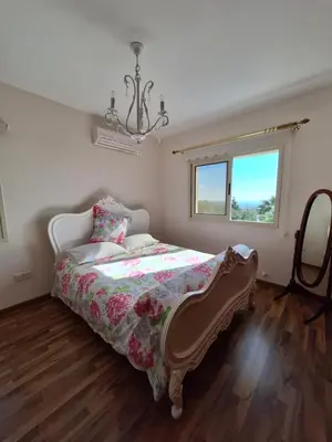 a bedroom with a bed and a window and a chandelier at ROSE VILLA - 3 BED POOL in Episkopi Lemesou