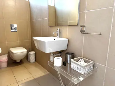 a bathroom with a sink and a toilet and a mirror at Wealthystays Niceday Hill Villa in Protaras