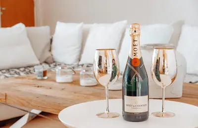 a bottle of champagne and two wine glasses on a table at Wealthystays Niceday Hill Villa in Protaras