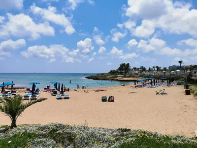 a beach with a lot of people and the ocean at Beach bliss apartment in Protaras