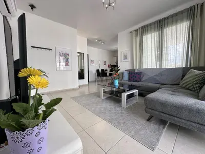 a living room with a couch and a table at Elegant & Central Two Bedroom Flat in Larnaka