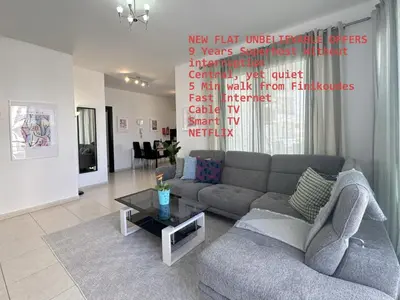 a living room with a couch and a table at Elegant & Central Two Bedroom Flat in Larnaka