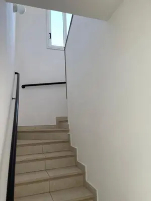 a staircase in a house with white walls and wooden floors at Villa Rhea in Ayia Napa