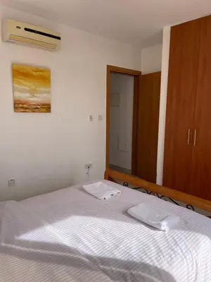 a bedroom with a bed with a mirror and a cabinet at Villa Rhea in Ayia Napa