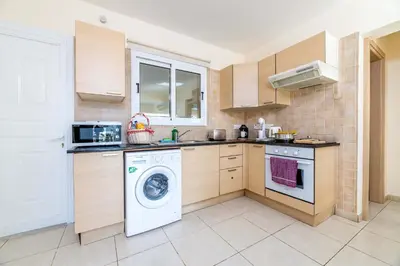 a kitchen with a washing machine and a washer at Estelle Suite in Ayia Napa