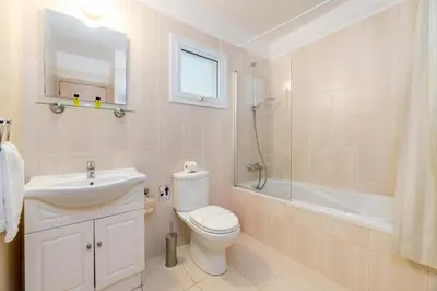 a bathroom with a toilet and a sink and a shower at Estelle Suite in Ayia Napa
