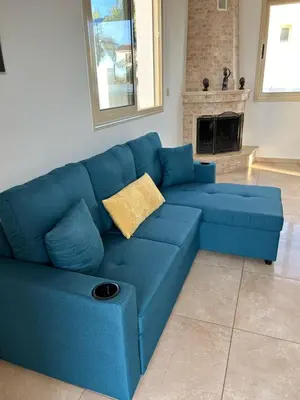 a blue couch in a living room with a fireplace at DAFNI VILLA BY PANN in Protaras