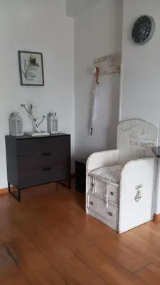 a living room with a white chair and a dresser at Sea view in Limassol