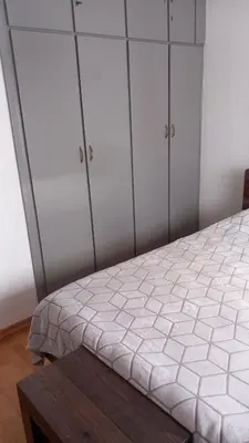 a bedroom with white cabinets and a bed with a table at Sea view in Limassol