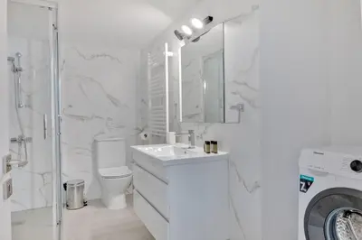 a white bathroom with a sink and a washing machine at Phaedrus Living: Luxury Residence Faneromeni in Larnaka