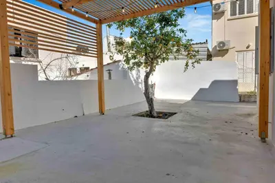 a courtyard with a tree in front of a building at Phaedrus Living: Luxury Residence Faneromeni in Larnaka