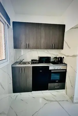 a kitchen with wooden cabinets and a stove top oven at Nicolas 1 in Larnaka