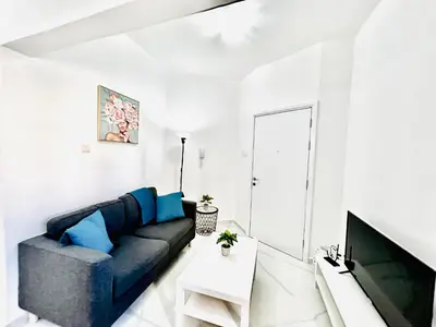 a living room with a blue couch and a tv at Nicolas 1 in Larnaka