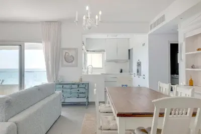 a kitchen and living room with a couch and a table at Phaedrus Living: Beach Front Flat Kyma in Limassol