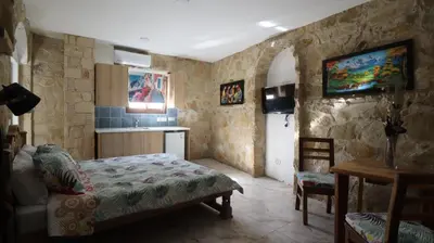 a bedroom with a bed in a room with stone walls at La Hacienda Cyprus in Limassol