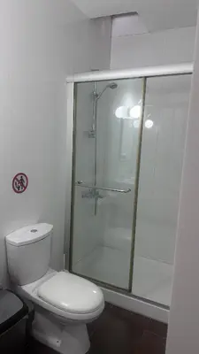 a bathroom with a toilet and a glass shower at Lovely studio in Makedonitissa in Nicosia