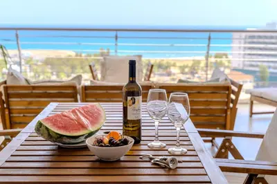 a table with a bottle of wine and wine glasses at Amazing Sea and Marina View City Center 2BDR Flat in Larnaka