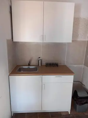 a kitchen with white cabinets and a sink at Πετροκτιστο in Kakopetria