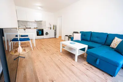 a living room with a blue couch and a table at COZY Apartment In Kapparis #2 in Paralimni