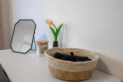 a table with a basket and a mirror and a flower at COZY Apartment In Kapparis #2 in Paralimni
