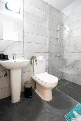 a white bathroom with a toilet and a sink at COZY Apartment In Kapparis #2 in Paralimni