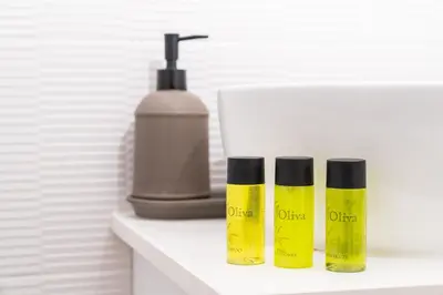 three bottles on a shelf next to a soap dispenser at Venus Apartment in Larnaka