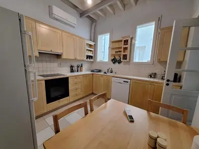 a kitchen with wooden cabinets and a wooden table at Pavlos Place - Blue Haven in Limassol